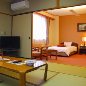 침대, 테이블, 의자가 있는 다다미 객실