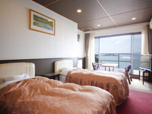 Lits jumeaux dans une chambre avec balcon et vue sur l’océan