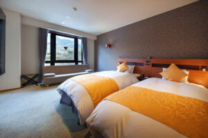 Letti singoli in una camera con divano