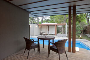 Patio couvert avec table, chaises et piscine extérieure