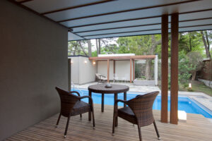 Patio couvert avec table, chaises et piscine privée
