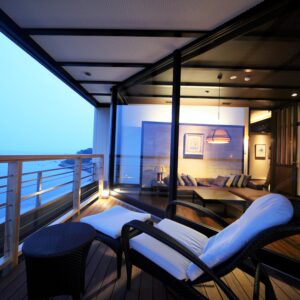 Poltrona lounge sul balcone accanto alla zona salotto in camera e al mare