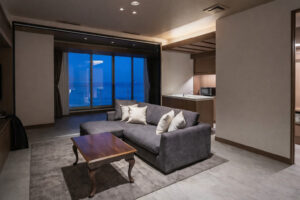 Zona giorno con divano, tavolo e finestre affacciate sull’oceano