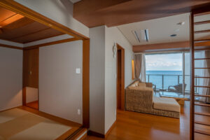 Angolo salotto in camera accanto al balcone con vista sull’oceano