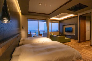 Due letti in una camera con balcone sull’oceano