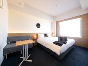 小さなソファとテーブルのそばにあるダブルベッド