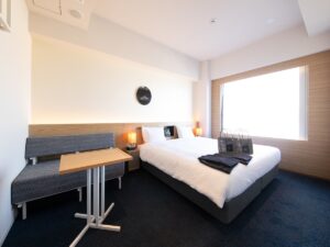 小さなソファとテーブルのそばにあるダブルベッド