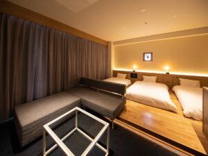 客室内のソファ横にある低いベッド2台