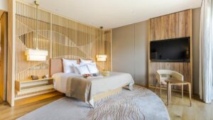 大きなベッドと壁掛けテレビのある寝室