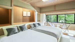 Two beds beside a window and seating area