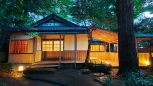 Esterno di un edificio ryokan tra gli alberi al crepuscolo