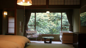 Camera in tatami con sedie accanto a una grande finestra sul giardino