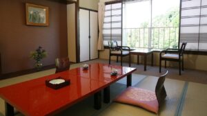 Habitación de tatami con mesa baja y sillas junto a la ventana