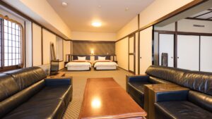 Habitación de estilo tatami con dos camas individuales y sofás de cuero