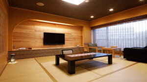 Tatami room with low table, chairs, and television