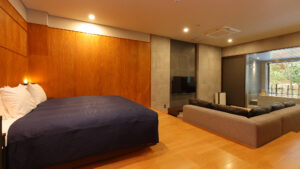 Dormitorio con cama grande, sofá y bañera junto a la ventana