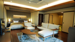 Dormitorio con dos camas individuales, sofá, sillas y mesa de centro