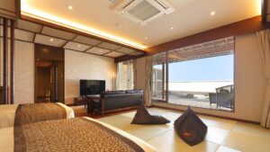 Habitación de tatami con camas, pufs, sofá y terraza abierta