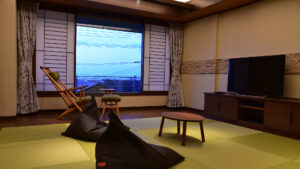 Habitación de tatami con sillas, pufs y televisión