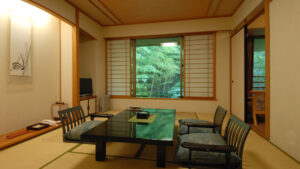 Habitación de tatami con mesa baja y sillas junto a la ventana