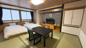 Tatami room with two beds, table, and television