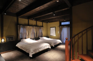 带两张白色床和木质天花板的卧室