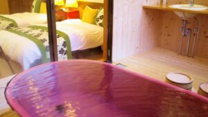 卧室和洗手台区域旁的红色木质浴缸