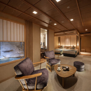 Zona de estar de la habitación con camas y ventana al baño privado