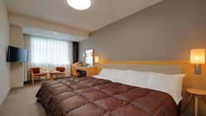 Cama grande con sillas y tocador en la habitación