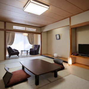 Habitación de tatami con mesa baja y sillas junto a la ventana