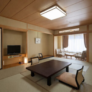 Habitación de tatami con mesa baja y asientos junto a la ventana