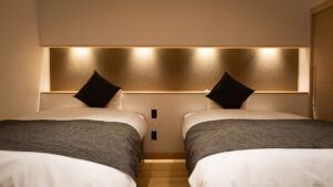 Two twin beds with gray bedding and black cushions