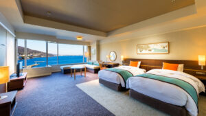 Lits jumeaux dans une chambre avec fenêtres sur l’océan