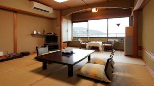 Habitación de tatami con mesa baja y zona de asientos junto a la ventana