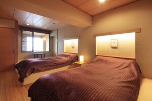 Dos camas en una habitación de huéspedes con iluminación suave