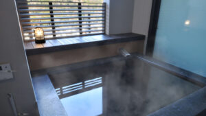 窓辺に湯気が立つ専用屋内風呂