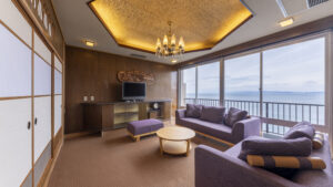 Sofa seating area beside large windows overlooking the sea