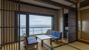 Tatami room with low table, chairs, and ocean window