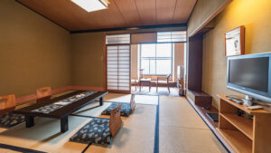Tatami room with low table, floor cushions, and window chairs
