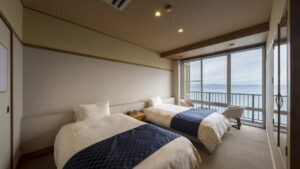 Twin beds beside a window overlooking the water