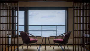 Two chairs by a window overlooking the ocean
