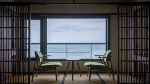 Two chairs by window facing ocean view
