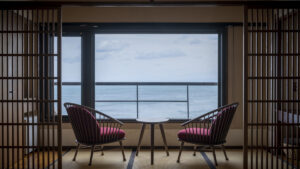 Two chairs by window overlooking the ocean
