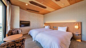 Due letti in una camera con sedie e tavolo