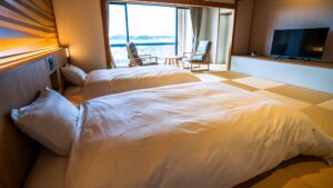 Due letti in una camera tatami con posti a sedere vicino alla finestra