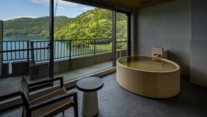 Round soaking tub beside window with lake view