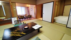 Tatami room with low table, chairs, and adjacent bed area