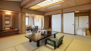 Tatami room with low table, chairs, and adjacent bedding