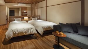 Twin beds beside a sofa in a Japanese-style room