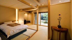 Bett in einem Tatami-Gästezimmer mit Fenster zum Garten